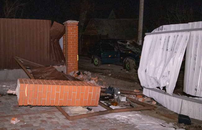 В Киеве пьяный водитель снес забор дома и уснул в машине патрульных: фото, видео