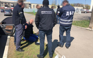Валютний хабар за український паспорт: ДБР затримало посадовця міграційної служби