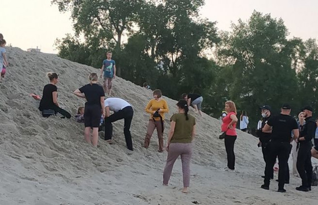 Достали синюю, но дышащую: на Оболонской набережной девочку засыпало песком, видео