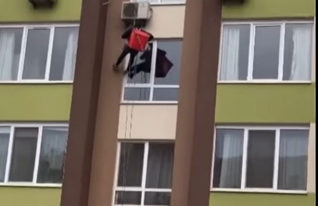 В Киеве курьер спустился с крыши, чтобы доставить еду через окно: видео