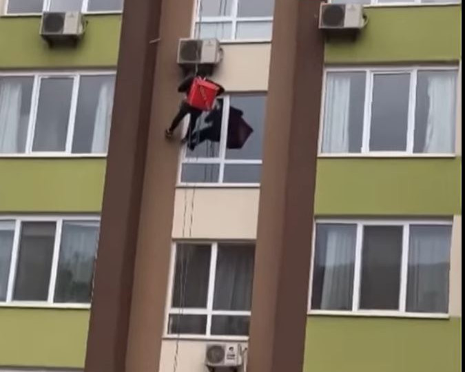 В Киеве курьер спустился с крыши, чтобы доставить еду через окно: видео