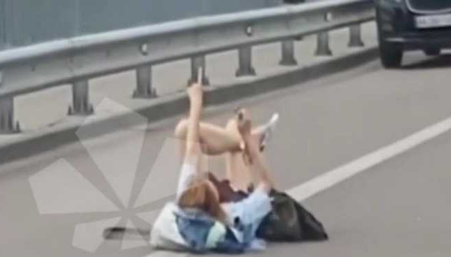 У Києві дівчина розляглася посеред дороги та махала водіям руками: є відео