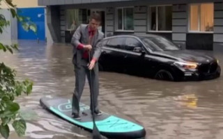 В Киеве парень в костюме и с веслом плыл по затопленной дороге, видео