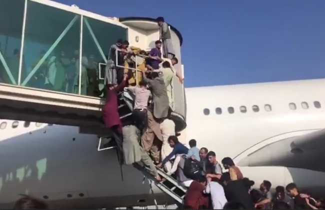 Люди цепляются за любую возможность улететь из страны: видео из аэропорта Кабула