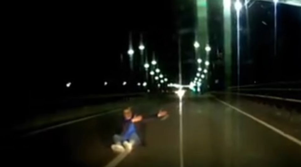 Чудом не сбили: в Киеве мужчина сидел на оживленной дороге и махал руками, видео