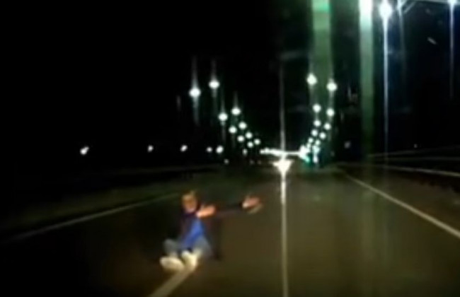 Чудом не сбили: в Киеве мужчина сидел на оживленной дороге и махал руками, видео
