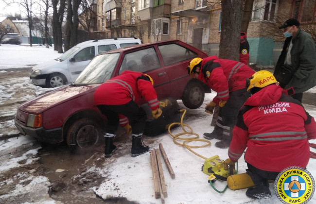 В Киеве возле жилого дома два автомобиля провалились в яму, фото