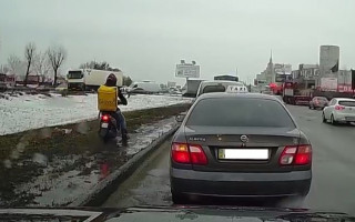 В Киеве курьер на мопеде по газону и грязи объехал пробку, видео