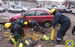 В Киеве возле жилого дома автомобиль провалился в яму, фото