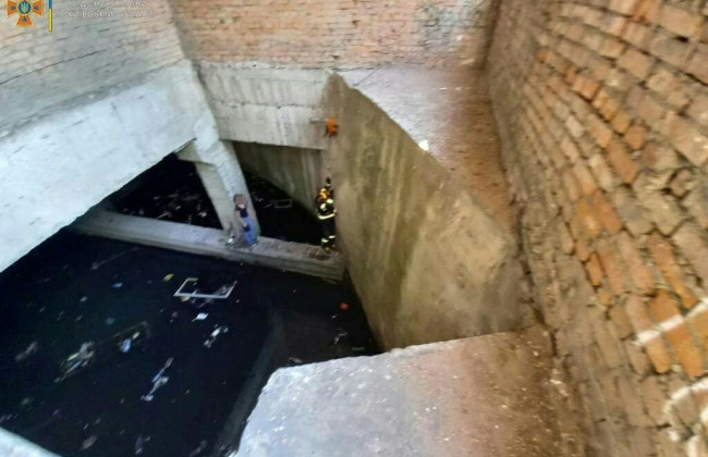 Спасатели ГСЧС достали из 5-метровой ямы с мусором и водой ребенка, фото