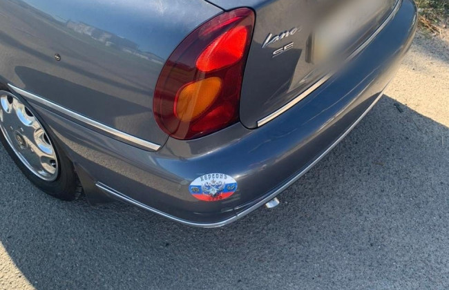 В Херсоні водій відбувся офіційним застереженням за наліпки прапора та герба рф