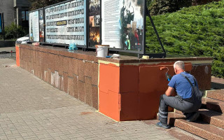 Гранитную плитку Украинского дома в Киеве окрашивают в оранжевый цвет, фото