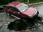 На Подольском спуске под колесами автомобиля провалилось дорожное покрытие